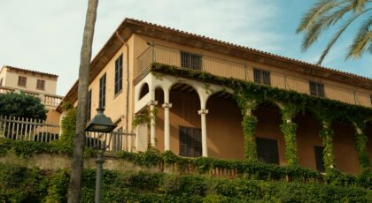 Charming Mediterranean villa with ivy facade in Balearic Islands, Spain. Captures sunny outdoor atmosphere.
