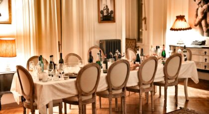 Luxurious dining room setup with bottles and glasses after a dinner party.