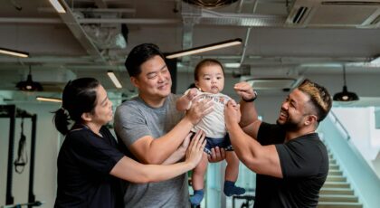 A joyful family moment captured indoors at a gym in Singapore, showcasing happiness and unity.