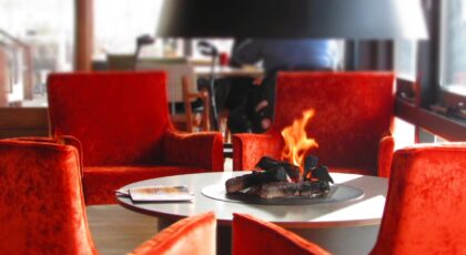 Luxurious dining space featuring a warm fireplace surrounded by contemporary chairs and elegant decor.