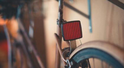 Close-up of a classic vintage bicycle featuring a red rear reflector and rusty frame indoors.