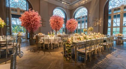 Luxurious wedding reception with elegant decor and floral arrangements in a grand hall.