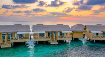 Stunning view of overwater bungalows in Maldives at sunrise, perfect for a tropical vacation.