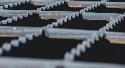 Detailed image of a sunlit iron grating, showcasing rugged texture and shadows.
