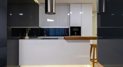 Interior of stylish kitchen with counter and appliances with cabinets glossy reflecting surface