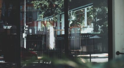 Reflection of urban street scene on modern glass building facade.