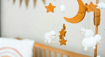 Wooden crib mobile featuring stars, a crescent moon, and fluffy sheep for a cozy baby nursery.