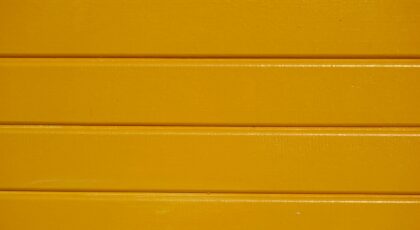 Close-up of yellow painted wooden planks with a clear textured finish.