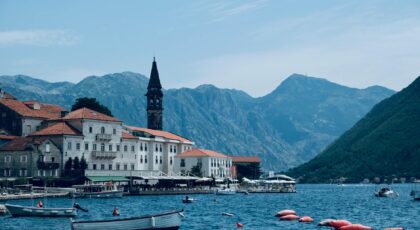 Explore the charming town of Perast, Montenegro, by the water with a stunning mountain backdrop.
