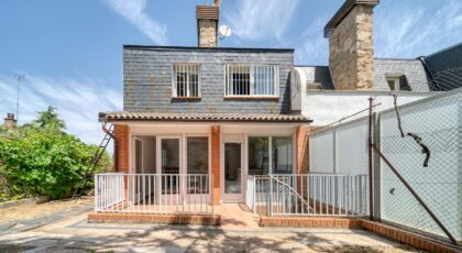 Stylish brick house exterior featuring a spacious patio and large windows on a sunny day.