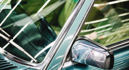 Detailed image of a luxury car's side mirror, window, and chrome trim.