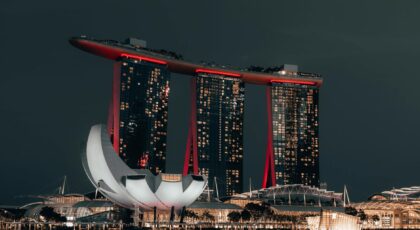 Dramatic night view of Marina Bay Sands, Singapore, with glowing cityscape and reflection.