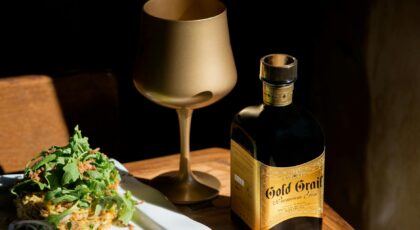 A sophisticated setting with premium gin, golden glass, and gourmet dish in Porto, Portugal.