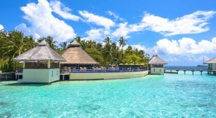 Idyllic overwater bungalows and lush greenery at a resort in Maldives, offering serene tropical paradise views.