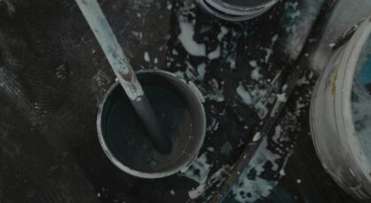 Aerial shot of paint buckets and tools on a construction site, showcasing a renovation project.