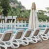 Elegantly lined sun loungers by the resort's poolside, creating a serene vacation vibe.