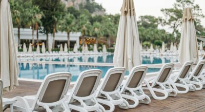 Elegantly lined sun loungers by the resort's poolside, creating a serene vacation vibe.