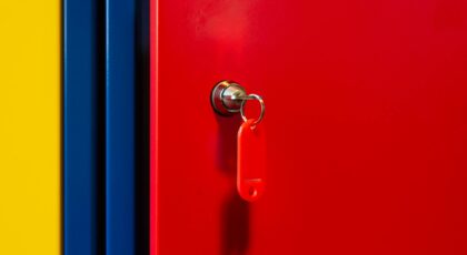 A vibrant image of a red locker door with a key in the lock, featuring bold primary colors.