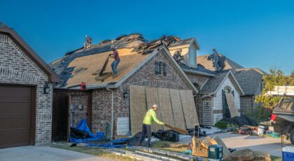 Workers engage in roof replacement on a brick house in Fort Worth, Texas.