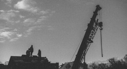 Silhouette of workers with crane on a construction site in Moscow, Russia.