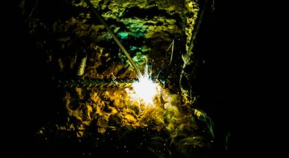 Dramatic capture of welding sparks illuminating a dark construction site with vivid light and texture.