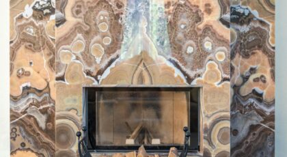 Luxurious marble fireplace with intricate patterns and stacked firewood, creating a warm ambiance.