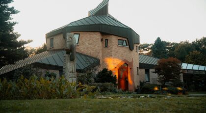 Striking modern house with artistic design and intriguing architecture, surrounded by lush greenery.