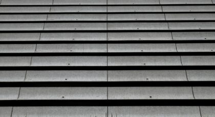 Aerial view of a monochromatic corrugated roof pattern emphasizing repetition and texture.