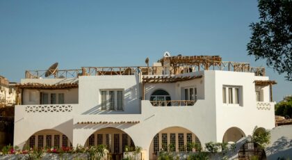 Elegant white villa in a sunlit desert setting, perfect for vacation or residential use.
