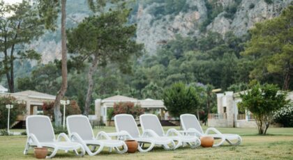 Peaceful resort garden with sunbeds and lush mountain backdrop, ideal for relaxation.