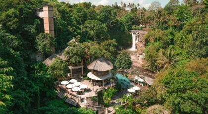 A serene tropical resort nestled in a lush forest in Ubud, Bali, featuring a stunning waterfall.