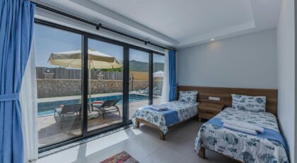 Luxury villa bedroom with twin beds and a view of the swimming pool, ideal for summer vacations.