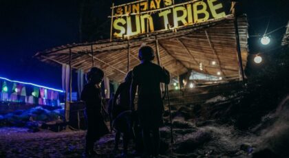 Children enjoy a night at Sun Tribe Beach Bar, Goa, India, under a starlit canopy.