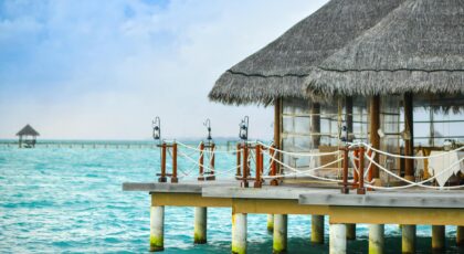 Scenic view of a tropical overwater bungalow on a crystal-clear sea, perfect for a luxurious vacation.