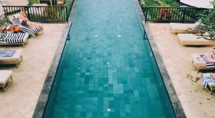 Relax in a serene infinity pool setting at a Bali resort surrounded by lush greenery.