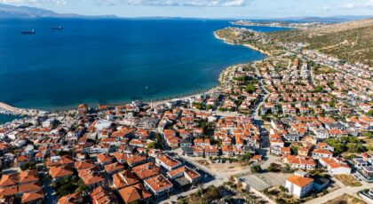 Stunning aerial view of a quaint coastal town with red rooftops along the Aegean Sea.