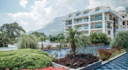 Elegant hotel with gardens, pool, and stunning mountain view, ideal for vacations.