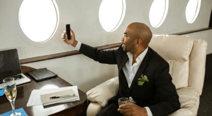 A businessman enjoying a drink and video call in a first-class private jet.