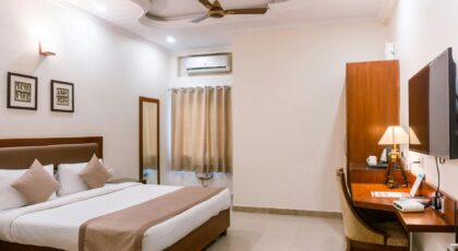 Comfortable hotel room featuring modern interior design with wooden furniture and soft lighting.