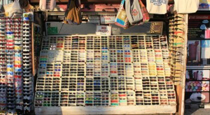 Vibrant display of sunglasses at a Venice Beach market stall, showcasing diverse styles in sunlight.