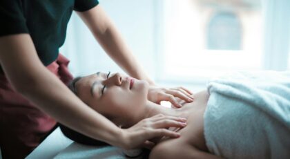 A serene spa massage session with a woman relaxing on a table, receiving a calming neck massage.