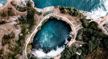 Stunning aerial view of the natural pool at Angel's Billabong with adjacent coastline in Bali.
