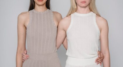Studio shot of two women embracing in minimalist fashion attire.