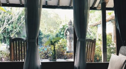 Relaxing bedroom overlooking lush garden in Marga, Bali. Serenity and comfort in a serene setting.