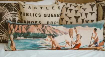 Decorative cushions with coastal illustration add an artistic touch to a bedroom setting.