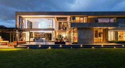 Explore a contemporary villa with a stunning facade, illuminated at dusk, highlighting its modern architecture.