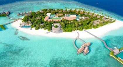 Aerial view of a serene tropical island resort surrounded by crystal-clear waters.