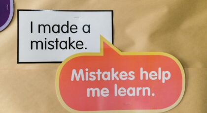 Bright square and speech bubble sign with motivational quotes about mistakes and learning.