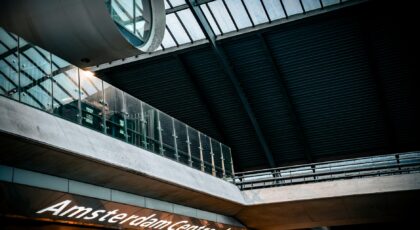 Interior view of Amsterdam Centraal Station with modern architectural design and signage.