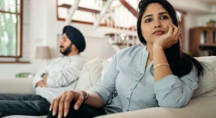 Young couple experiencing a conflict at home, showcasing emotional distance and contemplation.